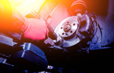 Cleaning disc brake on car, in process of new tire replacement. Cleaning disc brake on car, in process of new tire replacement. Car brake repairing in garage